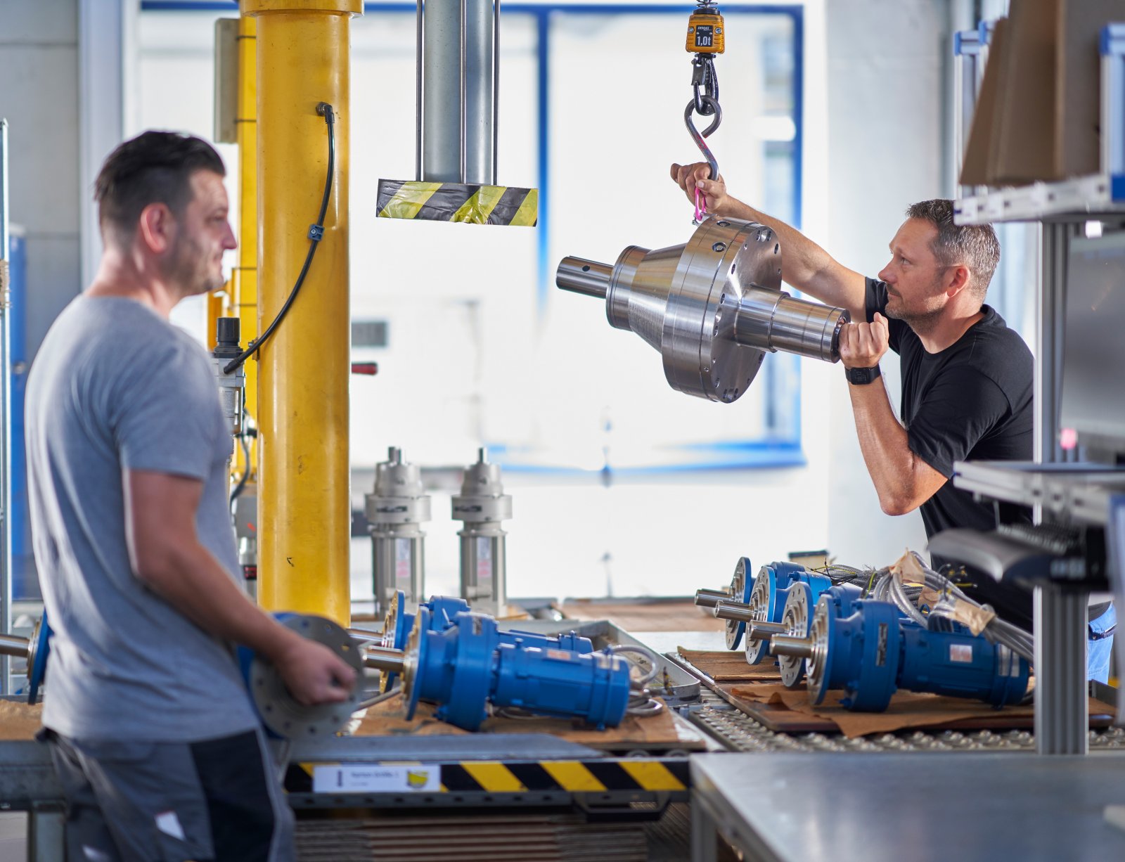 Mechanic lifting a gearbox with a small crane
